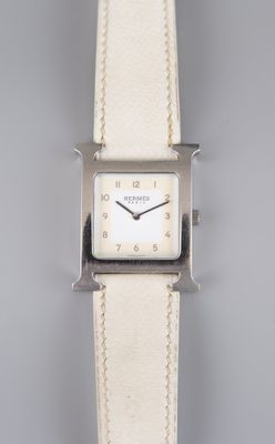 un gros plan d'une montre-bracelet avec un bracelet en cuir blanc