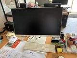 un bureau sur lequel se trouvent un écran d'ordinateur, un clavier, une souris et d'autres objets