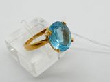 a close up of a gold ring with a blue topaz stone