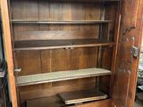 a wooden cabinet with a door open in a room
