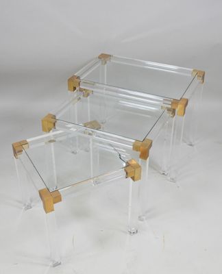 a pair of clear acrylic and brass coffee tables