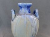 un vase bleu et blanc posé sur une table