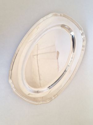 a silver tray with a mirror on it on the wall