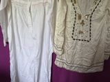 two white dresses hanging on a purple wall next to a purple wall