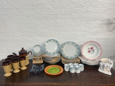many plates and cups sitting on a wooden table
