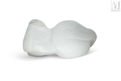 une figurine d'oiseau blanc posée sur une surface blanche