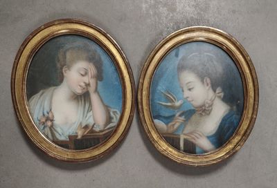 deux portraits encadrés représentant une femme et un enfant, dont l'un tient un oiseau dans ses mains