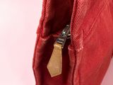 a close up of a red purse with a zipper