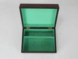 an open wooden box with a green lid sitting on a white surface
