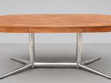 une table à manger ovale avec un piètement en métal et un plateau en bois