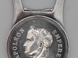 un décapsuleur en forme de pièce de monnaie sur laquelle est représenté le visage d'un homme