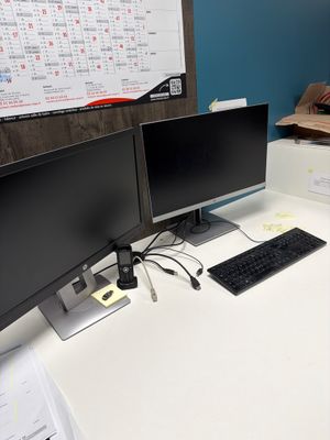 un bureau sur lequel sont posés deux écrans d'ordinateur et un clavier