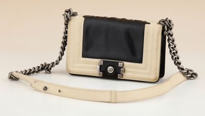a white and black handbag with a chain strap