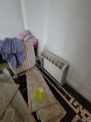 an image of a room with a heater and a bed