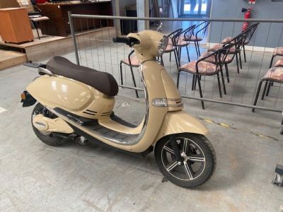 un scooter garé dans une pièce où se trouvent des chaises