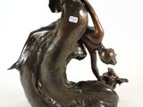 bronze statue of a woman holding a child on a rock