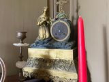 une horloge et une bougie posées sur une table dans une pièce