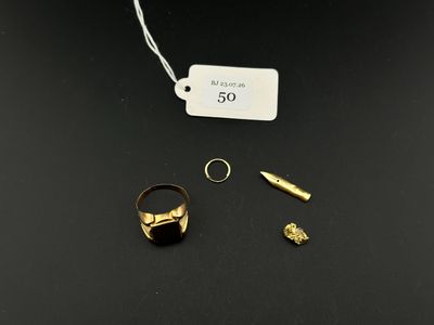 a close up of a gold ring with a bullet on a black surface