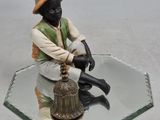 une figurine représentant un homme assis sur une table en verre