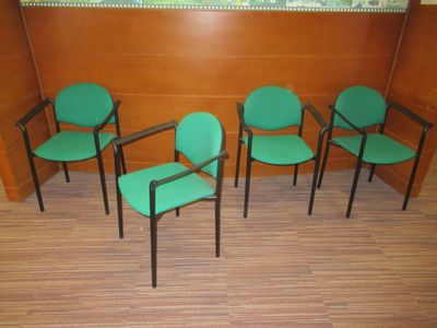 quatre chaises vertes dans un coin de la pièce