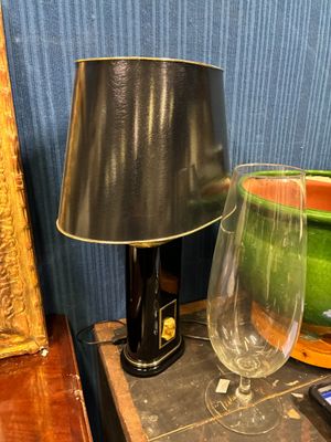 une table sur laquelle se trouvent une lampe et un verre à vin