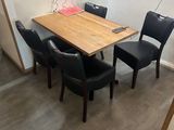 des tables et des chaises dans une petite pièce où est accroché un dessin au mur