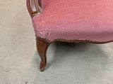 a pink chair that is sitting in the middle of a room