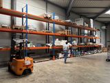 a man that is standing next to a forklift in a warehouse