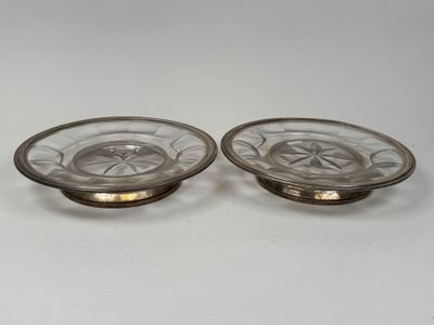 two glass dishes with gold rims on a white surface