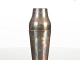 a silver vase sitting on a table with a white background