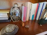 a book shelf with books, a vase, and other items on it