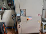 une photo montrant une machine dans un garage, avec un bébé dans une poussette