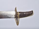 a close up of a sword with a gold handle on a white background