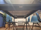 four blue chairs sitting under a table in a room