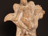 statue of a woman holding a child in a vase on a table