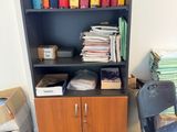 une bibliothèque contenant de nombreux dossiers, avec une chaise placée devant