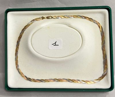 un gros plan sur un collier en or posé dans un écrin sur une table