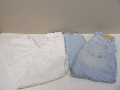 two pairs of white and blue jeans sitting on a table