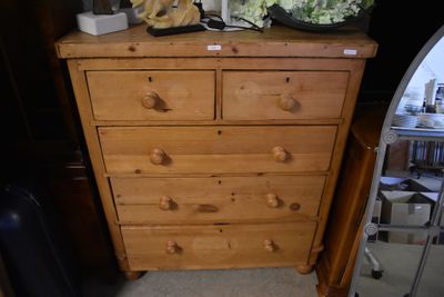 une commode en bois surmontée de fleurs
