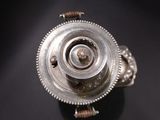 a close up of a silver object on a black surface