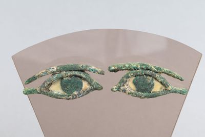 deux yeux verts qui se trouvent sur le côté d'un miroir