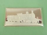 a silver plate with a train on it on a green surface
