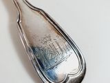 a silver spoon with a logo on it sitting on a table
