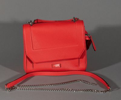 the small red bag is sitting on the table with a chain around it