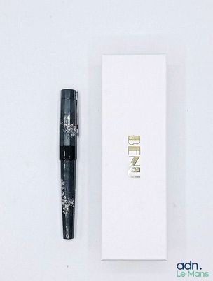 un stylo posé à côté d'une boîte blanche