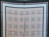 a picture of a pink and black plaid scarf hanging on a wall