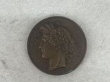 an old coin sitting on top of a white surface next to a piece of paper