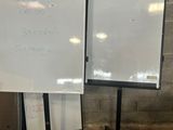 deux tableaux blancs posés par terre l'un à côté de l'autre