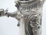 a close up of a silver coffee pot on a table