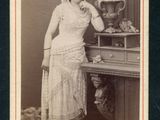 une vieille photo d'une femme debout devant une table